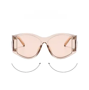 Detail of oversized Y2K sunglasses with amber frames and light peach pink lenses