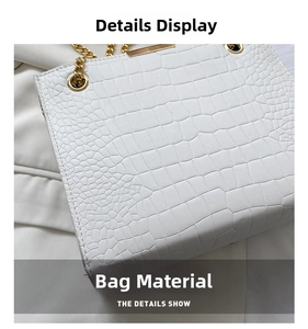 Detail view of white faux leather shoulder bag featuring crocodile embossed texture and gold eyelets