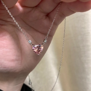 Pink heart-shaped pendant necklace with silver chain and side cubic zirconia accents
