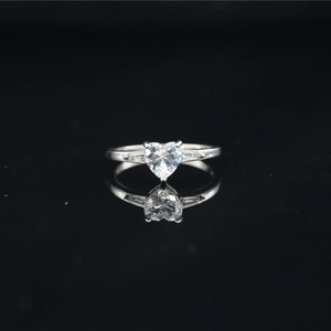 Classic silver heart-shaped moissanite ring with side stones on black reflective surface