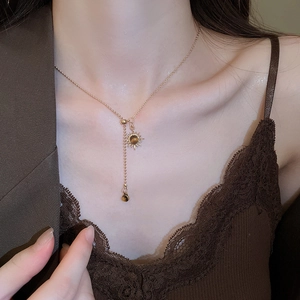 Gros plan du collier pendentif tournesol doré avec pierre œil de tigre sur un mannequin