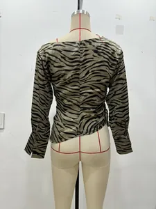 Detail der Damenbluse mit Tigermuster, Golddruck und geknöpften Manschetten am Ärmel