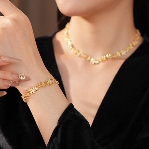 Détails de l'ensemble collier et bracelet doré avec maillons géométriques et zircons