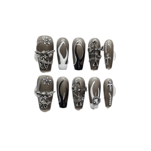 Punk gothic press-on nails with silver metal charms and black and white flame design