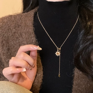 Detail of tiger eye sun pendant necklace with elegant fringe tassel on model's neck