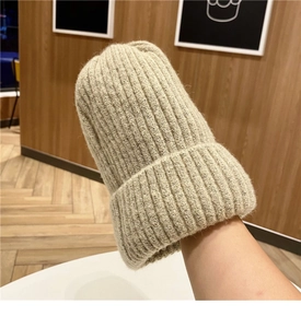 Dettaglio della trama del berretto in maglia beige con lana calda a coste