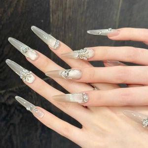 Detail of luxury press-on nails featuring cat-eye finish and 3D butterfly rhinestone accents