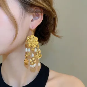 Vintage goldene Blumen-Ohrringe mit weißen Perlen und Quasten am Modell