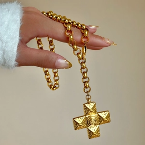 Detail of 18k gold plated chunky chain necklace featuring a textured cross and rose pendant