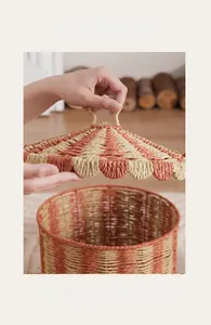 Close-up of hands lifting the lid of a hand-woven circus-style storage basket with red stripes