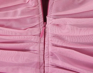 Dettaglio del retro dell'abito in mesh rosa con tessuto arricciato e cerniera invisibile