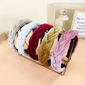 Padded velvet braided headband collection in various colors displayed on a gold stand