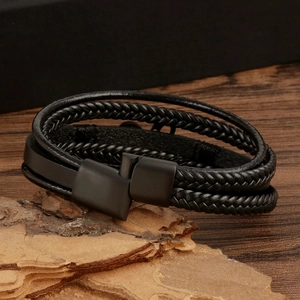 Macro shot of multilayered black braided leather bracelet with black magnetic metal clasp