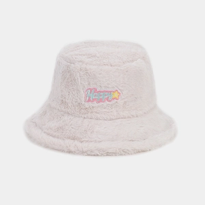 Détail d'un chapeau bob en peluche blanc cassé avec patch brodé Happy coloré