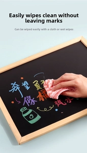 Close-up of hand cleaning the wooden frame blackboard surface with a pink cloth