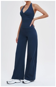 Detail of navy blue V-neck halter sports top and high-waisted wide-leg yoga trousers