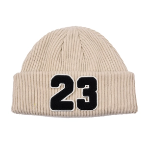 Detalle de gorro de punto acanalado beige con parche bordado del número 23