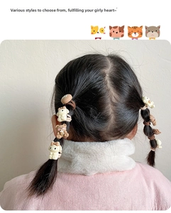 Close-up of children hair ties with cute cartoon bear and bunny charms on pigtails