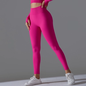 Detail view of pink high-waist yoga leggings with ribbed waistband and athletic seamless fit