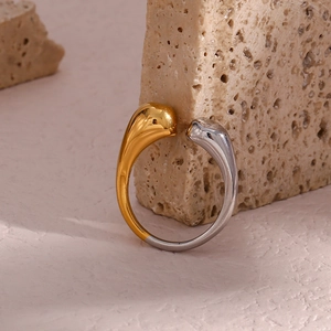 Detailed macro view of a dual-tone water drop ring in polished gold and silver metal