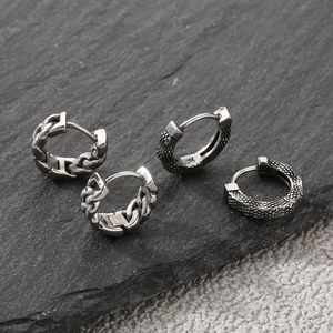 Detailed view of vintage silver Cuban chain and dragon scale textured hoop earrings