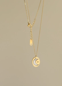 Detailed macro of 18K gold moon and star pendant with sparkling zircon and bead edge