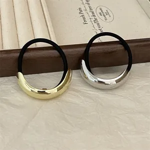 Detail showing gold and silver polished crescent alloy hair ties on a jewelry display box