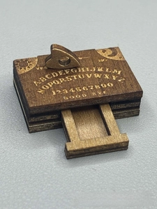 Detailed side view of wooden spirit board box with sliding drawer and laser engravings