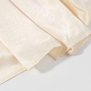 Detaillierte Makroansicht der beigen Satingewebe-Textur mit elegantem Glanz und Naht