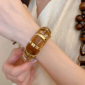Close-up of amber marble resin bracelet with gold metal rings on a model wrist