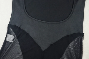 Detail of round neckline and sheer mesh patchwork stitching on black bodysuit