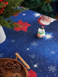 Top view of festive blue Christmas tablecloth with poinsettia, snow and snowman