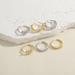 Macro detail of assorted geometric open rings with sparkling zircon in gold and silver