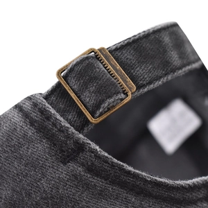 Close-up of vintage bronze metal buckle and washed denim texture on baseball cap