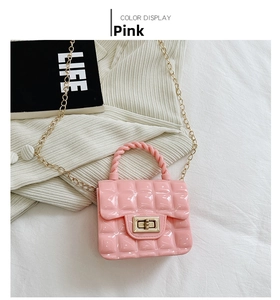 Detailed view of pink quilted PVC jelly bag with gold twist lock and chain strap
