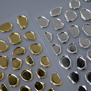 Adesivi per unghie astratti oro e argento su uno sfondo grigio in stile minimalista