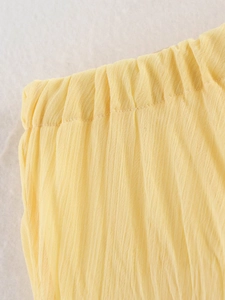 Detailed macro view of the elastic waistband and yellow pleated fabric texture