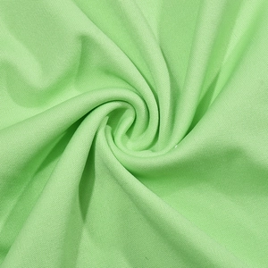 Détail du tissu en maille ajourée vert clair sur une robe d'été asymétrique chic