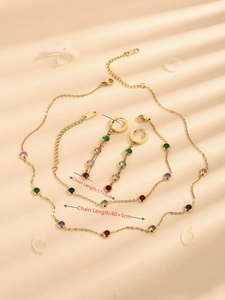Golden jewelry set with colorful crystals including necklace, bracelet and earrings