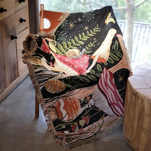 Detailed close-up of woven mushroom tapestry with colorful tassels on a leather chair