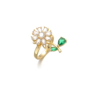 Detail of flower-shaped ring featuring white petals and green zircon leaf on golden band
