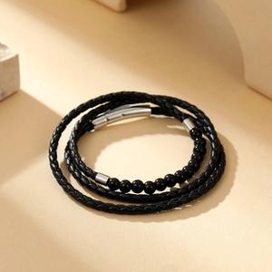 Detail of multi-layer black braided leather bracelet with onyx beads and silver clasp