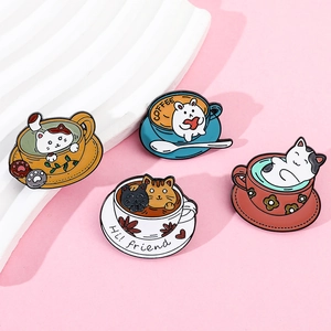 Detail of four colorful cat coffee cup enamel pins on a pink and white decorative set