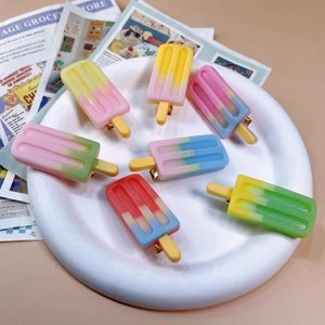 Colorful resin popsicle hair clips in vibrant gradients set on a white decorative plate