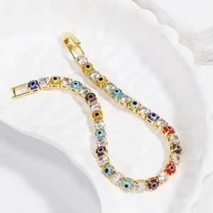 Close-up of golden tennis chain with colorful evil eye beads and sparkling cubic zirconia