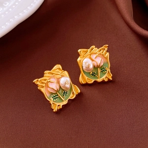 Detail of vintage enamel earrings featuring pink roses and gold oil-painting style frames
