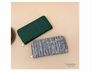 Close-up of long women's purses with striped textures and golden zipper hardware