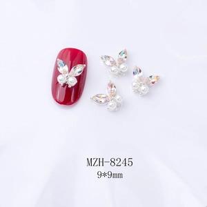 Détail breloques ongles papillon 3D 9x9mm avec cristaux AB et perles sur ongle rouge