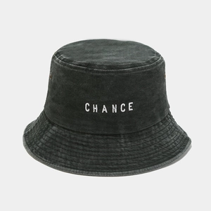 Detail view of washed cotton fabric and white CHANCE embroidery on dark grey bucket hat
