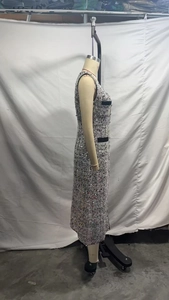 Detail of tweed sleeveless dress featuring black contrast piping and subtle sequins texture
